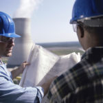 Two workers looking at blueprints