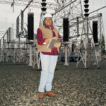Female worker holding clipboard at power station, portrait